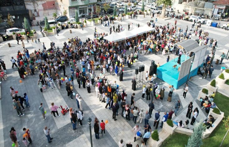 Kuş bakışı fotoğrafta, meydanda toplanan yüzlerce insanın elinde balonlar bulunuyor.