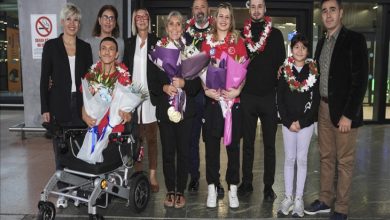 Para Yüzme Milli Takımı sporcuları Defne Kurt ve Umut Ünlü, teknik kadro ile sporcuların aileleri ellerinde tuttuklarını çiçeklerle poz veriyor.