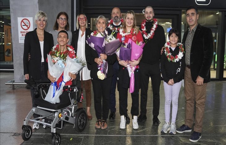 Para Yüzme Milli Takımı sporcuları Defne Kurt ve Umut Ünlü, teknik kadro ile sporcuların aileleri ellerinde tuttuklarını çiçeklerle poz veriyor.