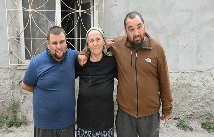 Anne ve iki engelli oğlu evlerinin önünde omuz omuza sarılarak poz veriyor.