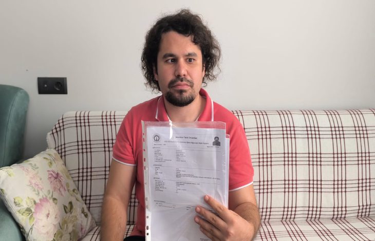 Görme engelli Adil Ahmet Kavrama, sınav belgesini elinde tutuyor.