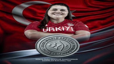 Görselde milli okçu Öznur Cüre Girdi yer alıyor. Sporcu, kırmızı Türkiye formasıyla gülümseyerek poz vermiş. Arka planda dalgalanan büyük bir Türk bayrağı bulunuyor. Alt kısımda gümüş madalya görseli öne çıkarılmış. Yazılarda, “Dünya Para Okçuluk Şampiyonası – Kadınlar Makaralı Yay” kategorisinde madalya kazandığı belirtiliyor. Ayrıca görselin altında Türkiye Milli Paralimpik Komitesi logosu yer alıyor.