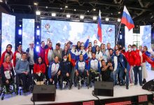 Rus Paralimpik Sporcular ellerinde ülke bayrakları tutarak sahnede bulunuyor.