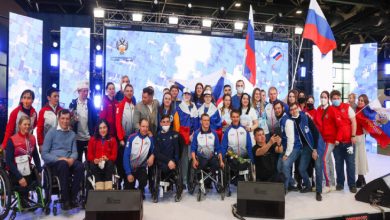 Rus Paralimpik Sporcular ellerinde ülke bayrakları tutarak sahnede bulunuyor.