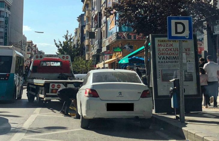 Beyaz otomobil çekici vasıtasıyla kaldırılıyor.