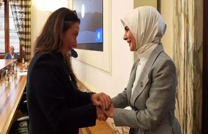 Aile ve Sosyal Hizmetler Bakanı Mahinur Özdemir Göktaş, İtalya Engelliler Bakanı Alessandra Locatelli ile ayakta el ele tutuşarak gülerek sohbet ediyor.