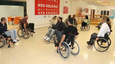 Eğitim salonunda tekerlekli sandalye kullanan belediye personelleri bulunuyor.