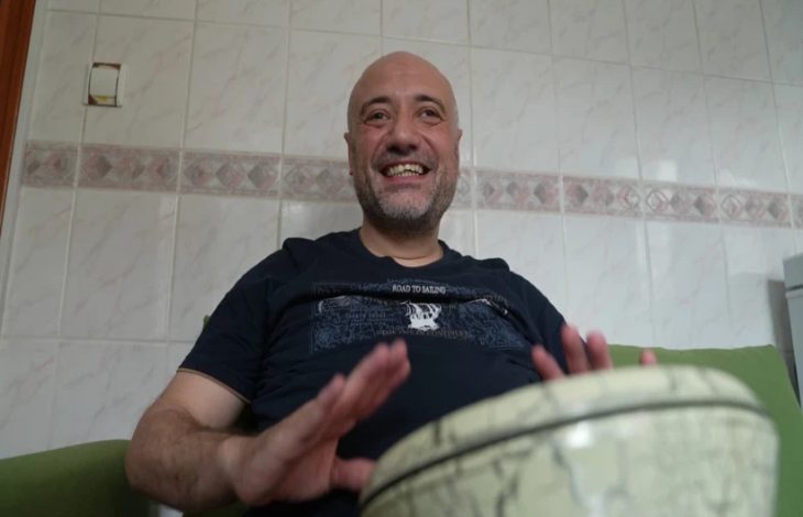 Emrah Erdem, gülerek darbuka çalıyor.