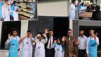 Görselde, önlük giymiş bir grup kişi bir kafenin önünde poz veriyor ve gülümseyerek el sallıyor. Aralarında down sendromlu bireyler de bulunuyor. Üst kısımdaki küçük karelerde ise aynı kişilerin kafede çalıştıkları, müşterilere hizmet ettikleri ve tezgâh arkasında görev yaptıkları görülüyor. Fotoğraf, kapsayıcılığı ve toplumsal farkındalığı yansıtan sıcak bir ortam sunuyor.