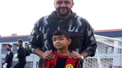 Eskişehirspor Kulüp Başkanı Ulaş Entok arkada ayakta dururken, önde bulunan Eskişehirspor forması giyen Hamit Özbek'in omuzlarını tutarak poz veriyor.
