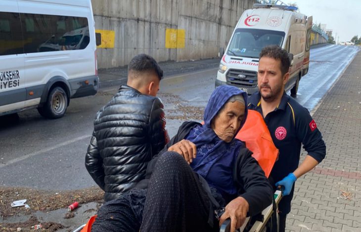 Sağlık personeli ve genç bir erkek vatandaş sedyede yatan engelli kadını götürüyor.