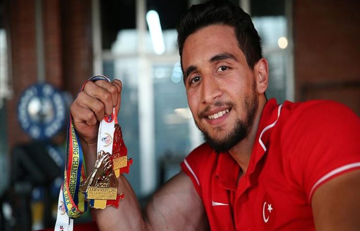 Paralimpik atlet Fatih Kamuz elinde tuttuğu madalyalarla poz veriyor.