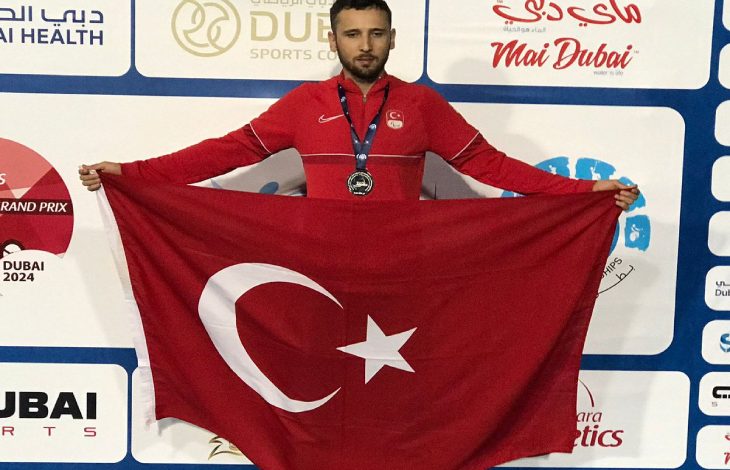 Para atletimiz Oğuz Akbulut, Türk Bayrağı tutarak poz veriyor.