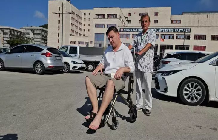 Aytaç Öztürk, tekerlekli sandalyede bulunuyor ve yakını olan erkek aracı sürüyor.