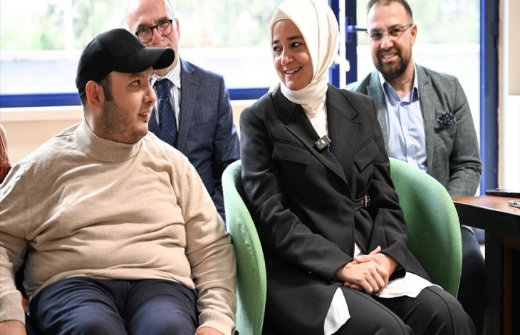 AK Parti Genel Başkan Yardımcısı Fatma Betül Sayan Kaya, yanında koltukta oturan engelli erkek bireyle sohbet ediyor.