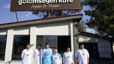 Gülümseyen Kafe önünde özel gereksinimli personeller poz veriyor.