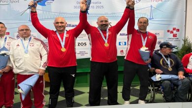 Para Atıcı Erkek Milli Takımı sporcuları Muharrem Korhan Yamaç, Murat Oğuz ve Çağrı Yılmaz el ele tutuşarak, kolları havada kürsüde bulunuyor.