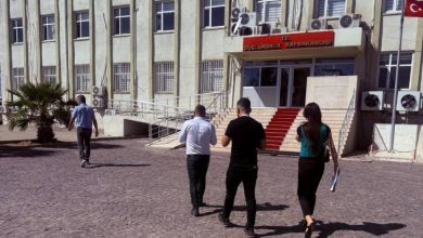 Erişilebilirlik İzleme ve Denetleme Komisyonu üyesi bir kadın ve iki erkek Güçlükonak Kaymakamlığı önünde yürürken.