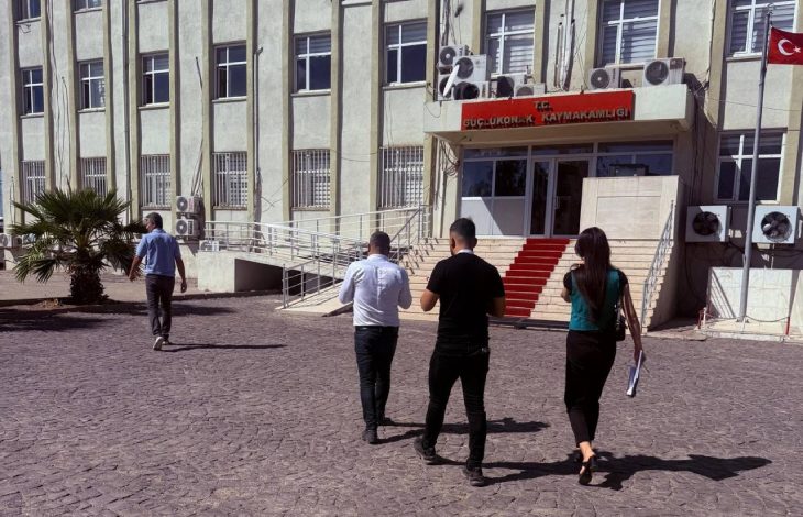 Erişilebilirlik İzleme ve Denetleme Komisyonu üyesi bir kadın ve iki erkek Güçlükonak Kaymakamlığı önünde yürürken.