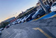 Görselde, yere mavi renkle işaretlenmiş engelli park yerlerinin tamamına yakınında araçların park ettiği bir otopark alanı görülüyor. Araçlar yan yana dizilmiş durumda ve engelli bireyler için ayrılan alanların dolu olduğu net biçimde anlaşılıyor. Arka planda binalar ve “Eczane” tabelası dikkat çekiyor. Sahne, engelli park yerlerinin sürekli meşgul olmasına dair yaşanan sorunu yansıtıyor.