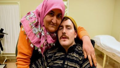 Gülsüm Kabadayı, bakımını üstlendiği felçli gence sarılarak poz veriyor.