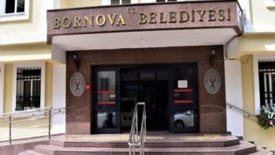 Bir binanın girişinde “T.C. Bornova Belediyesi” tabelesi yer alıyor. Girişte merdivenler, rampalar ve belediye amblemleri görülüyor.