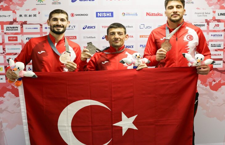 Milli sporcular Şenol Aydın, Kadir Kuş ve Ahmet Talha Kacur, madalya ile Türk Bayrağı tutarak poz veriyor