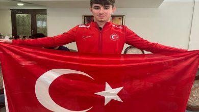 Milli sporcu Enes Burç, Türk Bayrağı tutarak poz veriyor.