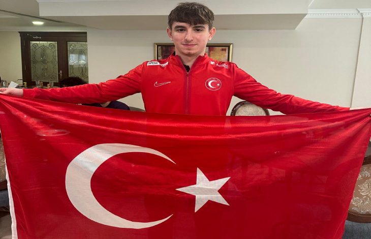 Milli sporcu Enes Burç, Türk Bayrağı tutarak poz veriyor.