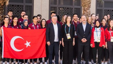 Gençlik ve Spor Bakanı Osman Aşkın Bak ve TBMM Engelli Bireylerin Sorunlarını Araştırma Komisyonu Başkanı Mehmet Muharrem Kasapoğlu, önde yer alıyor. Arkalarında ise Suudi Arabistan'daki 6. İslami Dayanışma Oyunları'na katılan milli sporcular ve Türk bayrağı yer alıyor.