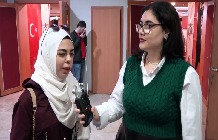 Görme Engelli Avukat Ruveyda Bilge Özmen karşısında duran elindeki kayıt cihazını tutan gözlüklü bir kadın tarafından röportajı yapılıyor.