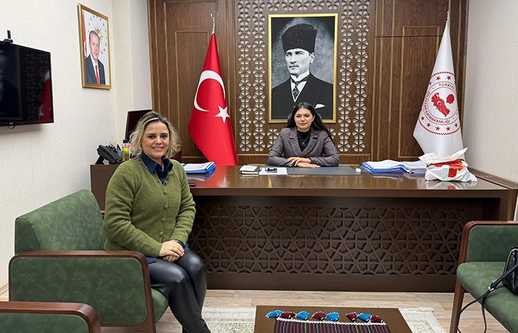 İki kişinin yer aldığı resmi bir makam odasında, masada oturan kişi Trabzon Şalpazarı Kaymakamı Kezban Yerlikaya Akpınar; sol tarafta, koltukta oturan ise Engelsizkariyer.com Genel Müdürü Hasibe Kızıltaş’tır. Arka planda Türk bayrağı, kaymakamlık flaması ve Atatürk portresi yer almakta; ortam resmi ve kurumsal bir görüşmeye işaret etmektedir.