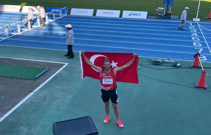 Milli Sporcumuz Yasin Süzen sırtında tuttuğu Türk Bayrağını havaya kaldırarak pistte poz veriyor.