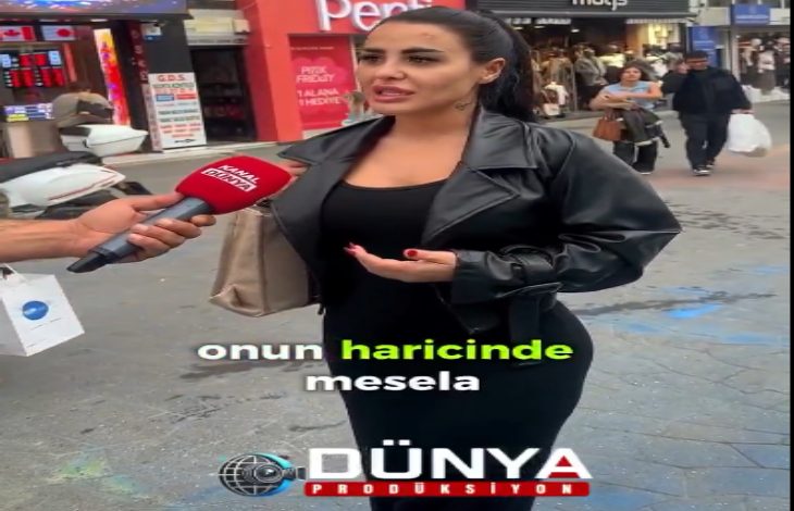 Kalabalık bir caddede yapılan sokak röportajında, siyah kıyafetli bir kadın mikrofon uzatılarak konuşurken görülüyor. Arkada mağazalar ve yürüyen insanlar var; görüntünün altında “Dünya Prodüksiyon” logosu yer alıyor.