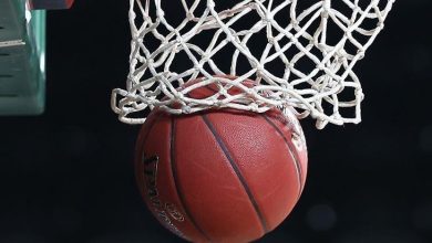 Fotoğraf, potaya doğru süzülen bir basketbol topunu gösteriyor. Top fileye takılmak üzere ve tam “swish” anının yakalandığı o tatlı, kusursuz saniye… File beyaz, pota altı karanlık bir zemine karşı net biçimde öne çıkıyor. Enerjik, hareket dolu bir kare.