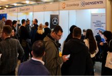 Kalabalık bir grup, Garanti BBVA, Mercedes, Eczacıbaşı ve Gensenta stantlarının yer aldığı bir fuar alanında buluşmuş. Katılımcılar firmalarla görüşüyor, bazıları bilgi alıyor.