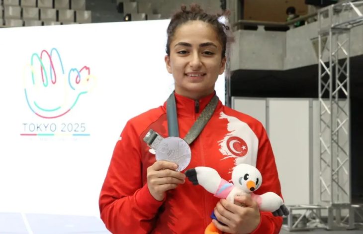 Milli sporcu Buse Tıraş madalya tutarak poz veriyor.