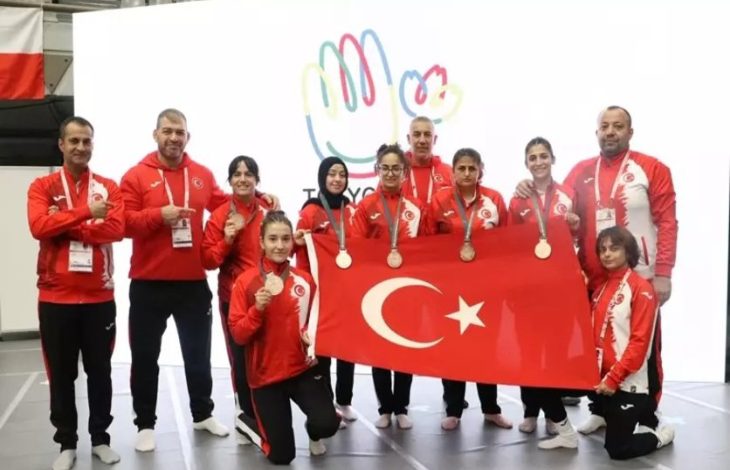 Türkiye İşitme Engelli Judo Milli Takımı,.teknik kadro ile kazandıkları madalya ve Türk Bayrağı tutarak poz veriyor.