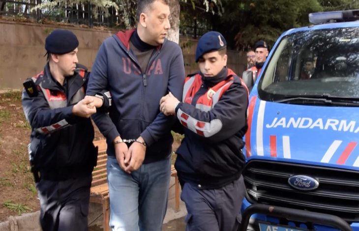 Ellerinde kelepçe bulunan okul müdürünü iki jandarma personeli götürüyor.