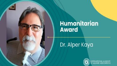 Görselde, bir erkeğin portre fotoğrafı yer alıyor. Sağ tarafta “Humanitarian Award” başlığı ve altında bir isim yazılı. Alt köşede ise bir kuruluşun logosu ve adı bulunuyor. Tasarım genel olarak bir ödül duyurusu formatında hazırlanmış.