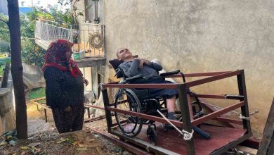 Demirden yapılan rampa sistemi teleferikte, tekerlekli sandalyesiyle Tunahan oturuyor. Annesi ise yanında bekliyor.