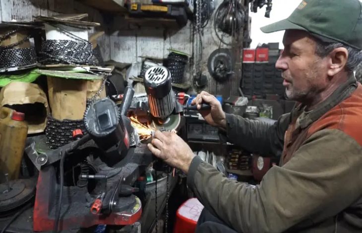 Tamir atölyesinde çalışan Hüseyin Erkal, elindeki ekipmanı taşlama makinesine tutarak zincir benzeri bir parçayı keskinleştirip onarmaya çalışırken kıvılcımlar etrafa saçılıyor.