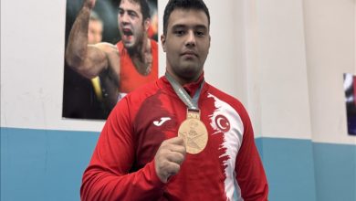 İşitme engelli güreşçi Seymen Berke Nergiz madalyasını tutarak eski milli güreşçi ve Türkiye Cumhuriyeti Gençlik ve Spor Bakanı Yardımcısı Hamza Yerlikaya'nın posterinin önünde poz veriyor.