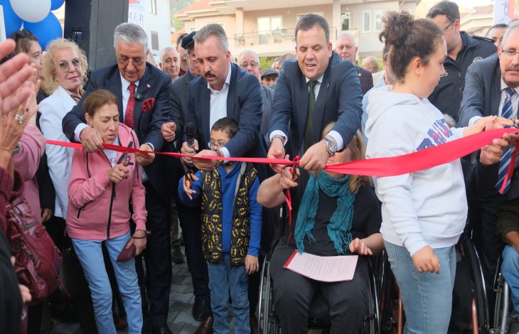 Kemer Belediyesi Mola Evi'nin açılış kurdelesini yöneticiler ve engelli bireyler kesiyor.