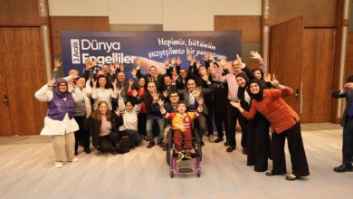 Manisa Büyükşehir Belediye Başkanı Besim Dutlulu, engelliler ve aileleriyle el kaldırarak poz veriyor.