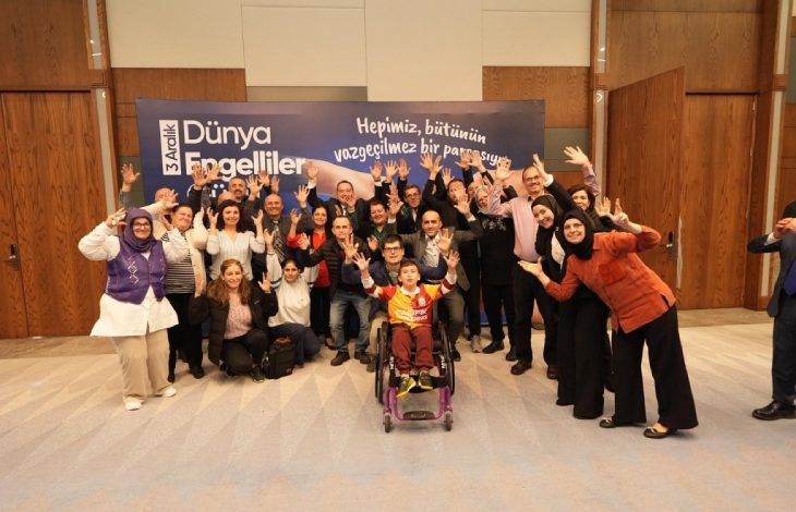 Manisa Büyükşehir Belediye Başkanı Besim Dutlulu, engelliler ve aileleriyle el kaldırarak poz veriyor.