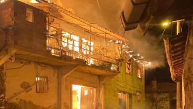 Alevler içinde yanan iki katlı köy evi.