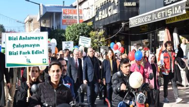 Kortej yürüyüşünde engelliler, yakınları ile yöneticiler ellerinde döviz ve balon tutarak bulunuyor.