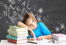 Görselde, masada kitaplar arasında oturan küçük bir çocuk görülüyor. Çocuk başını koluna yaslamış, önündeki deftere dalgın ve yorgun bir ifadeyle bakıyor. Arka planda ise tahtaya dağınık hâlde yazılmış harfler ve semboller yer alıyor; bu da öğrenme sürecindeki zihinsel karmaşayı çağrıştırıyor.