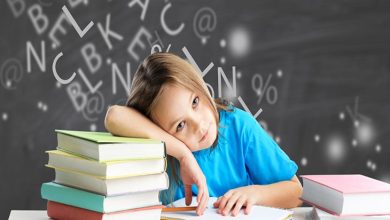 Görselde, masada kitaplar arasında oturan küçük bir çocuk görülüyor. Çocuk başını koluna yaslamış, önündeki deftere dalgın ve yorgun bir ifadeyle bakıyor. Arka planda ise tahtaya dağınık hâlde yazılmış harfler ve semboller yer alıyor; bu da öğrenme sürecindeki zihinsel karmaşayı çağrıştırıyor.